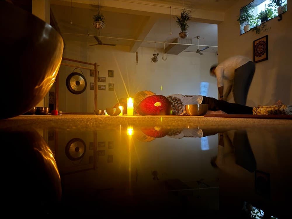Serene floor reflection with singing bowls and candlelight
